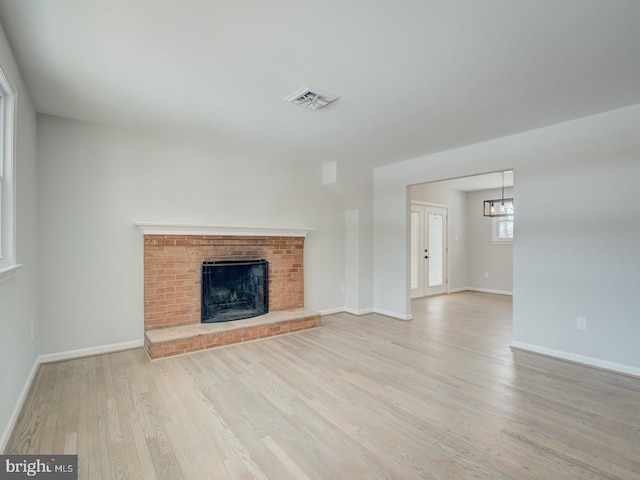 unfurnished living room featuring a fireplace and light hardwood / wood-style floors