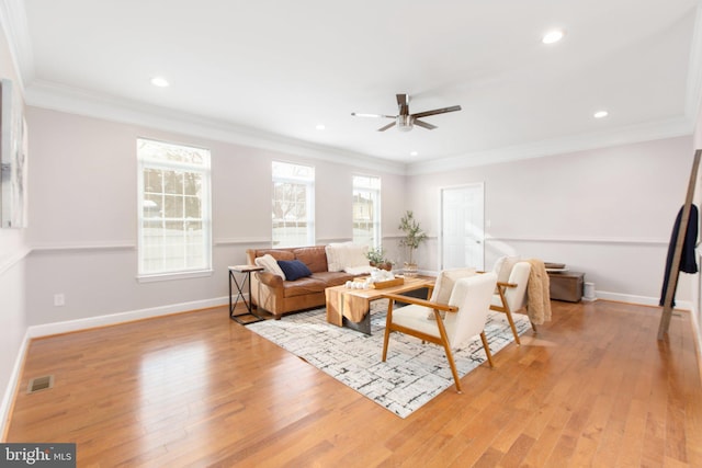 living room with ceiling fan, ornamental molding, and light hardwood / wood-style flooring