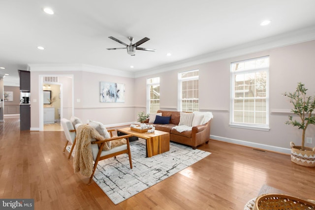 living room with ceiling fan, ornamental molding, and light hardwood / wood-style floors