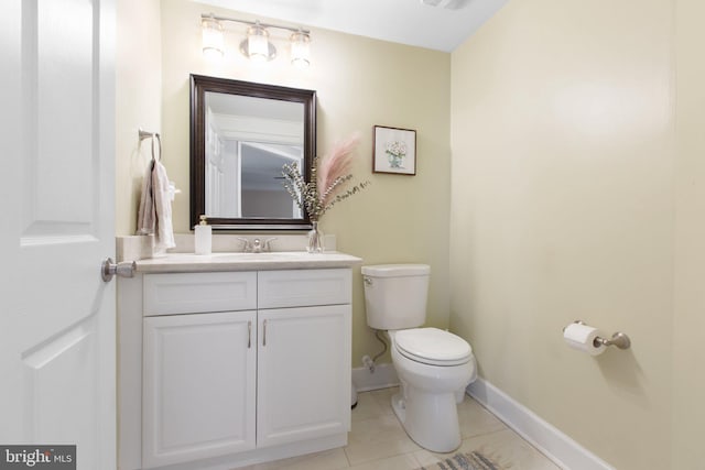 bathroom with tile patterned flooring, vanity, and toilet