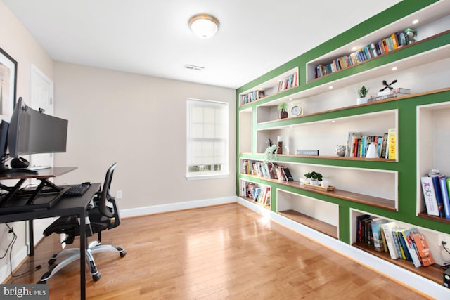 home office with light hardwood / wood-style floors