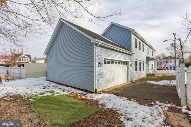 snow covered property with a garage