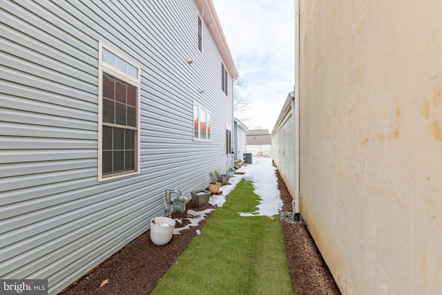 view of property exterior featuring central air condition unit and a lawn