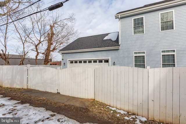 snow covered property with a garage