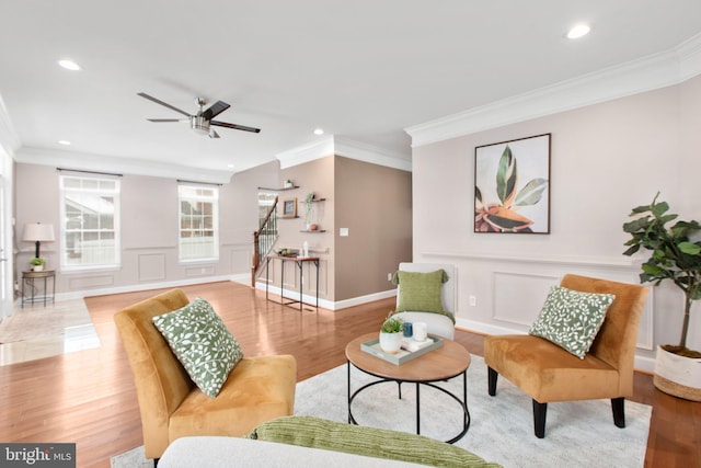 living room with crown molding, ceiling fan, and hardwood / wood-style flooring