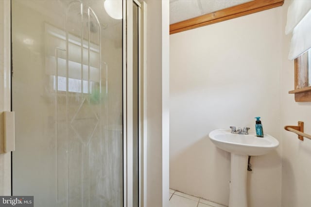 bathroom with an enclosed shower and tile patterned floors