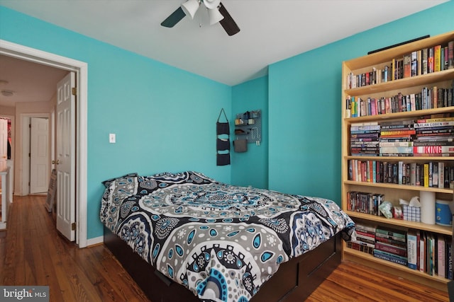 bedroom with dark hardwood / wood-style flooring and ceiling fan