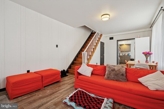 living room with wooden walls and wood-type flooring