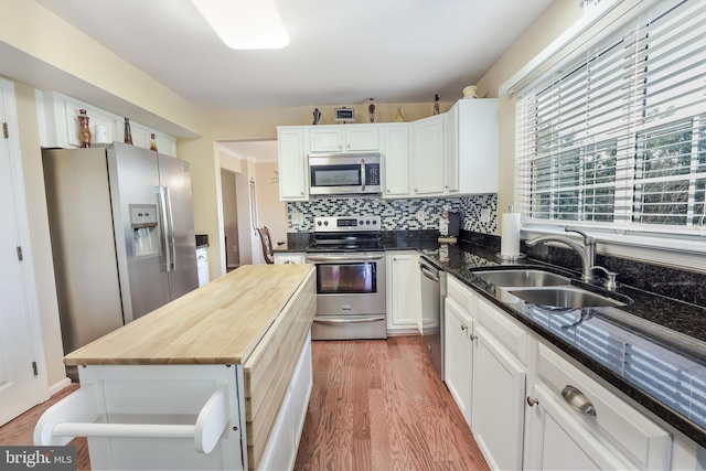 kitchen featuring sink, white cabinetry, a kitchen island, hardwood / wood-style flooring, and stainless steel appliances