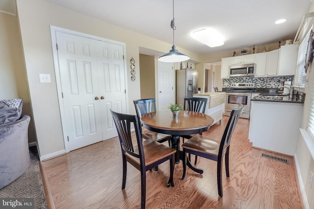 dining space featuring sink and light hardwood / wood-style flooring