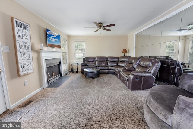 carpeted living room with a wealth of natural light and ceiling fan