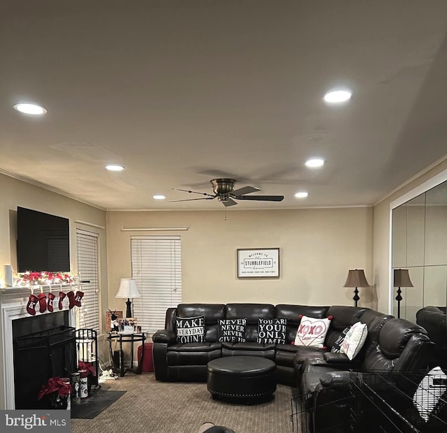 living room with carpet floors, ornamental molding, and ceiling fan