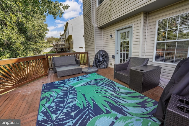 wooden terrace with an outdoor living space