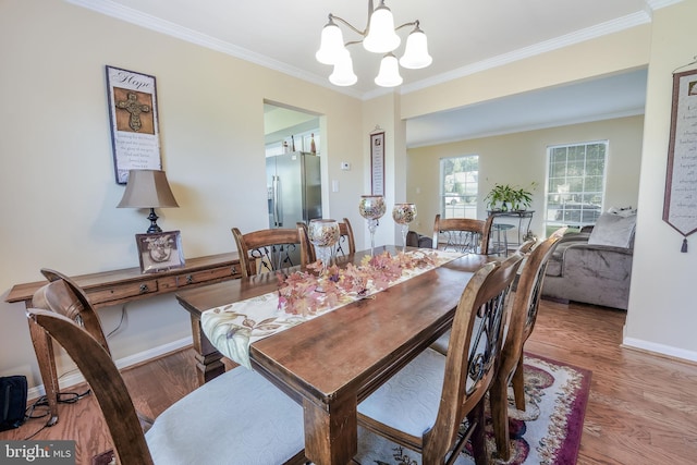 dining area featuring crown molding, wood-type flooring, and a chandelier