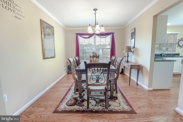 dining area featuring crown molding, an inviting chandelier, and light hardwood / wood-style flooring