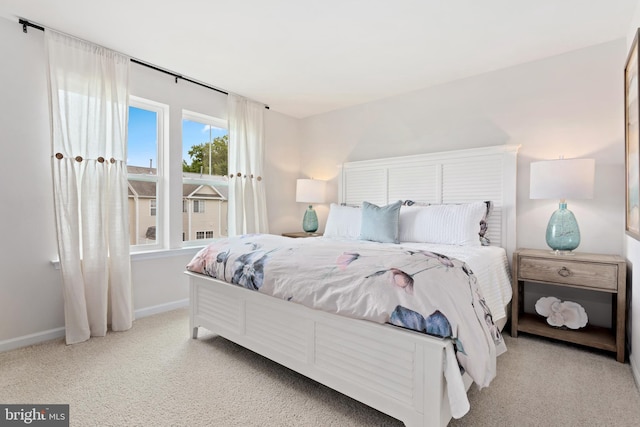 bedroom featuring multiple windows and light carpet