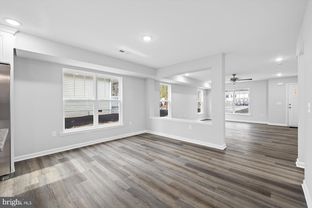 unfurnished living room featuring ceiling fan and dark hardwood / wood-style flooring