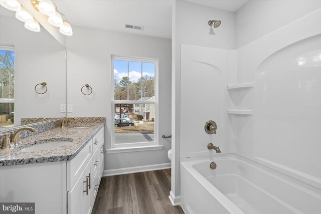 full bathroom with shower / tub combination, wood-type flooring, vanity, and toilet