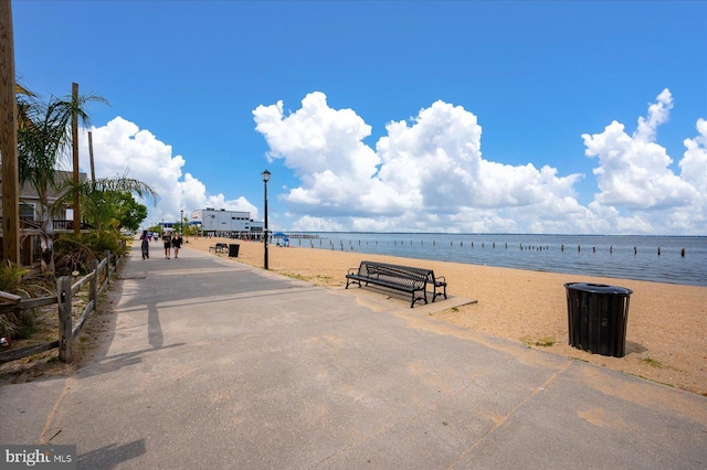 view of property's community with a water view and a beach view