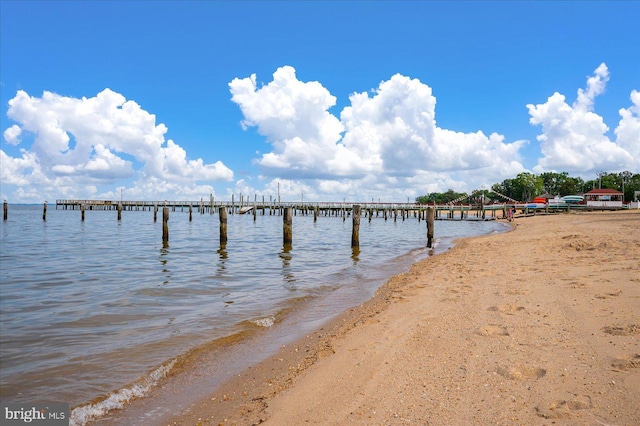 view of water feature featuring a view of the beach and a boat dock