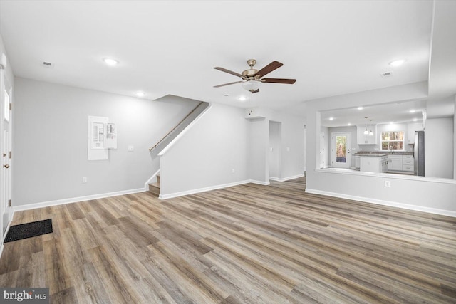 unfurnished living room featuring ceiling fan and light wood-type flooring