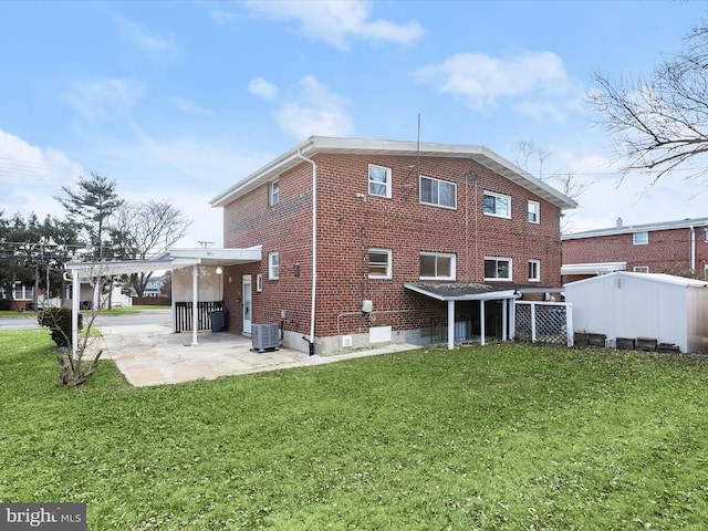 rear view of property with central AC unit, a lawn, and a patio area