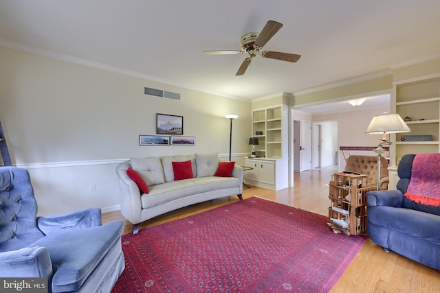 living area featuring ornamental molding, visible vents, and light wood finished floors