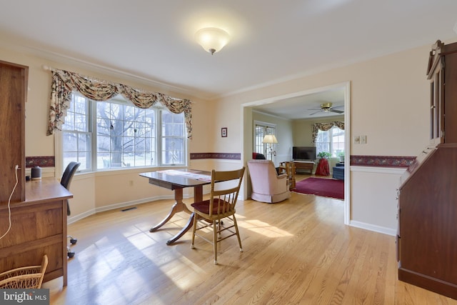 dining space featuring a healthy amount of sunlight, light wood finished floors, visible vents, and crown molding