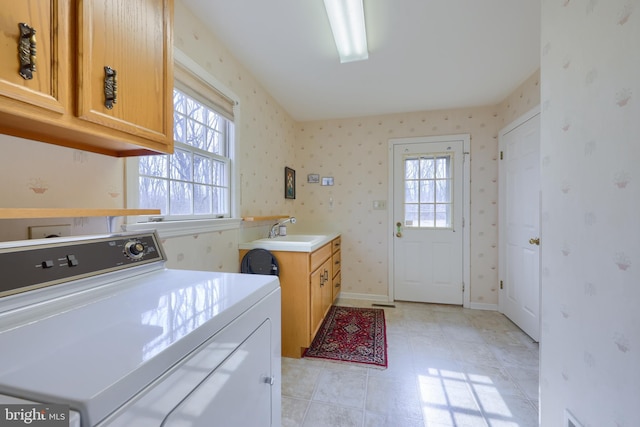 laundry room featuring a sink, baseboards, washer and dryer, cabinet space, and wallpapered walls