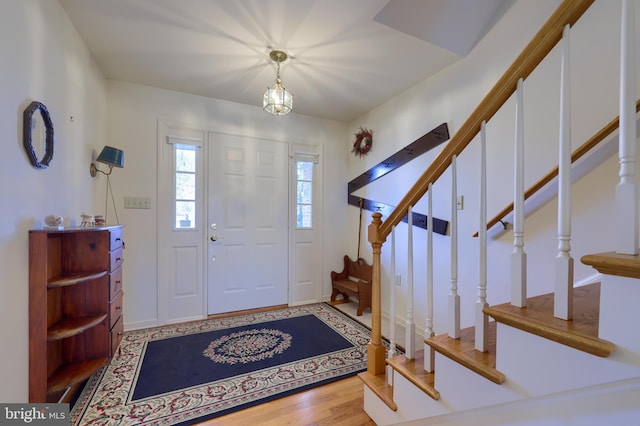 entryway with wood finished floors and stairs