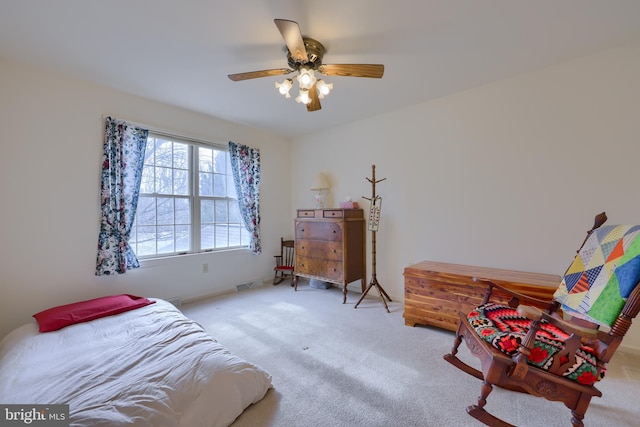 carpeted bedroom with a ceiling fan and visible vents