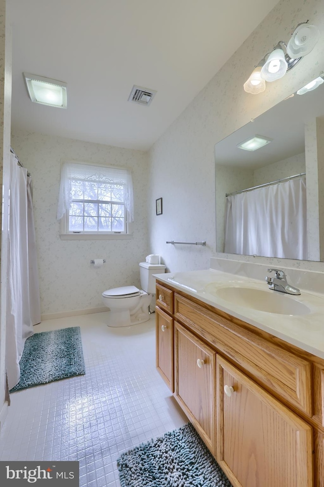 bathroom featuring toilet, vanity, visible vents, and wallpapered walls