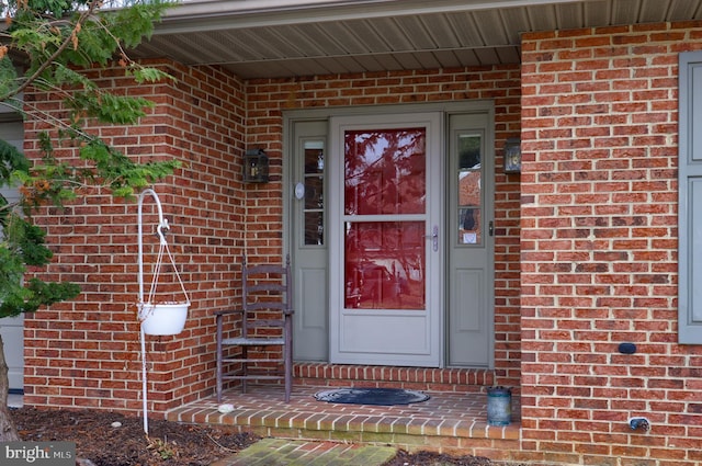 property entrance featuring brick siding