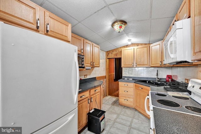 kitchen with a paneled ceiling, tasteful backsplash, white appliances, sink, and lofted ceiling