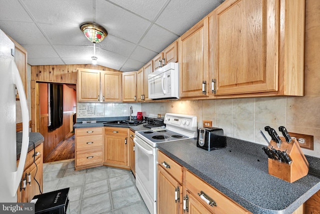 kitchen with decorative backsplash, white appliances, sink, light brown cabinets, and lofted ceiling