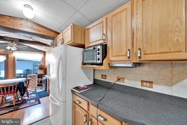 kitchen featuring ceiling fan, white fridge, and tasteful backsplash