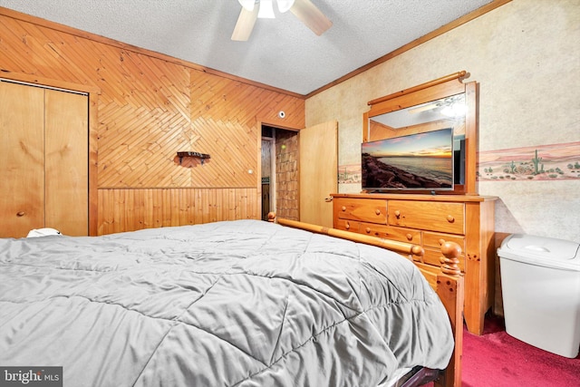 carpeted bedroom featuring a textured ceiling, ceiling fan, ornamental molding, and wood walls