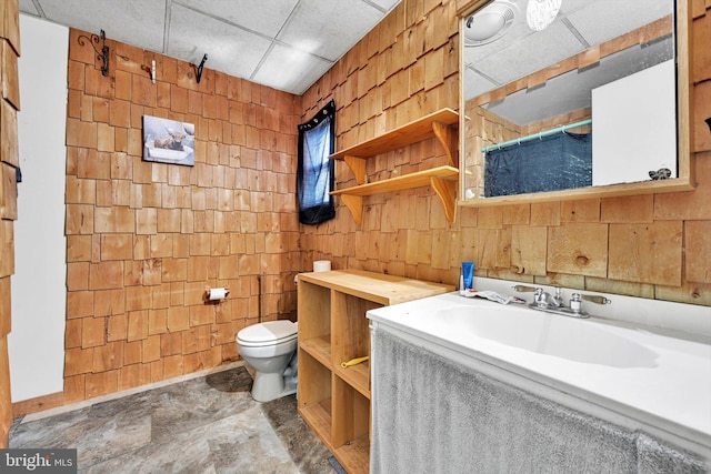 bathroom with a paneled ceiling, vanity, and toilet