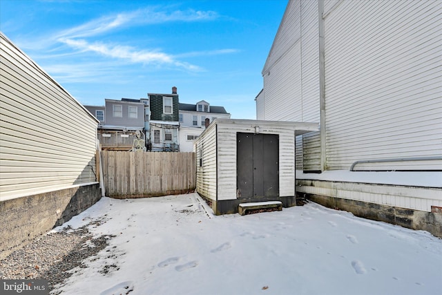 snowy yard featuring a storage shed