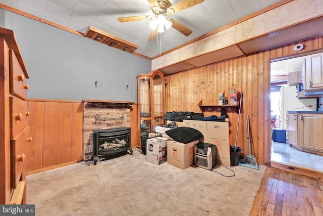 living room with ceiling fan, light carpet, and wood walls