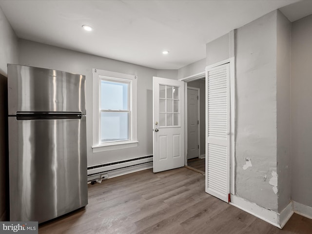 kitchen with light hardwood / wood-style floors, a baseboard radiator, and stainless steel fridge