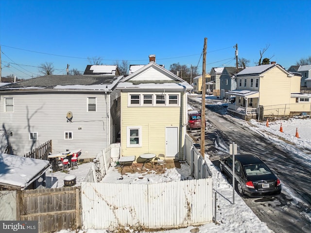 view of snow covered back of property