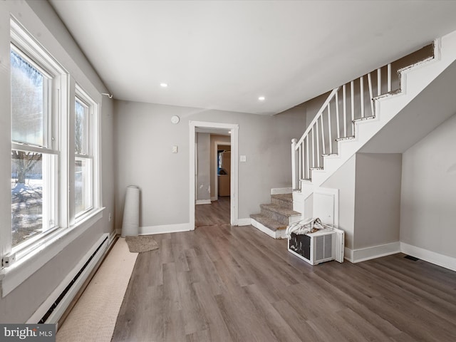 interior space featuring a healthy amount of sunlight, baseboard heating, and wood-type flooring