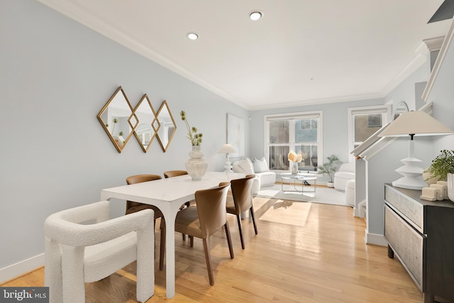 dining room with crown molding and light hardwood / wood-style flooring