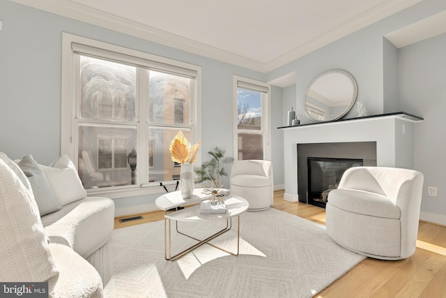 living room featuring ornamental molding and light hardwood / wood-style floors