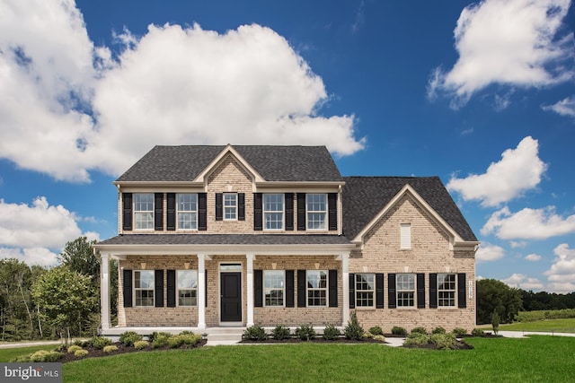 colonial inspired home featuring a front lawn