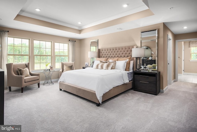 bedroom featuring a tray ceiling and light colored carpet