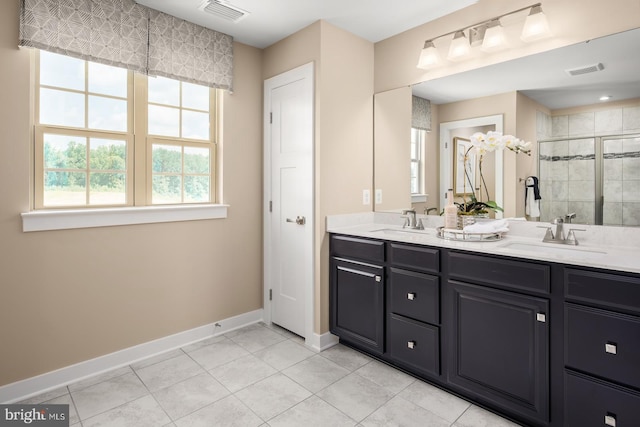 bathroom with vanity, a shower with shower door, and tile patterned flooring