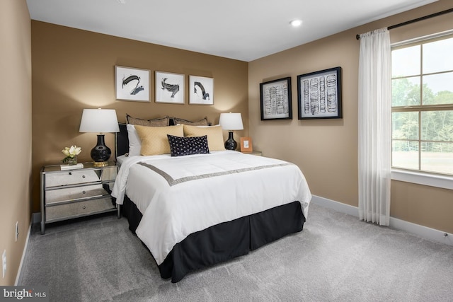 bedroom with multiple windows and dark colored carpet