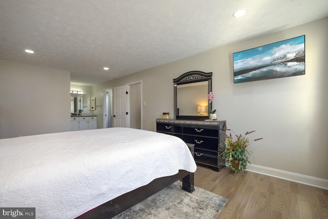 bedroom with hardwood / wood-style flooring and a textured ceiling